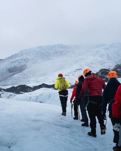 Glacier hike group in colourful windbreakers on vatnajokull glacier on a gloomy summer day