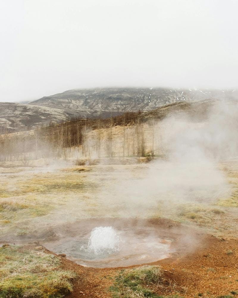 Hot spring bubbling in the Geysir area in the Golden Circle on a cloudy fall day