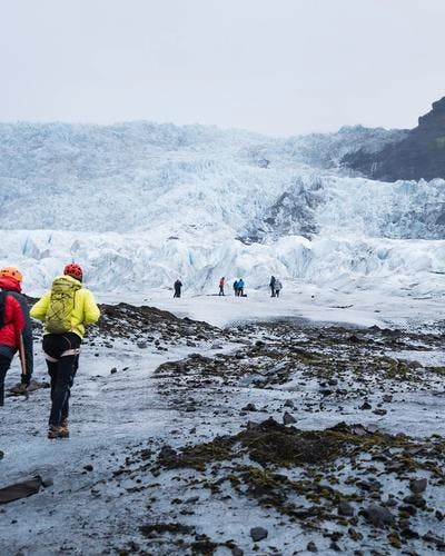 glacier hike tour setting off to vatnajokull glacier in colourful windbrekars on a sunny day